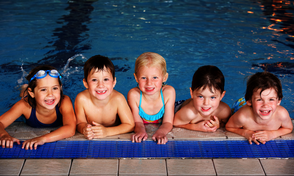 Gruppe von Kindern im Schwimmkurs im Hallenbad